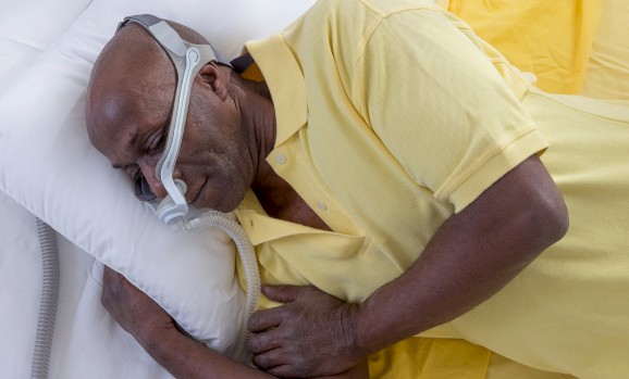 Cover photo for a medical blog - Man sleeping with their CPAP machine.